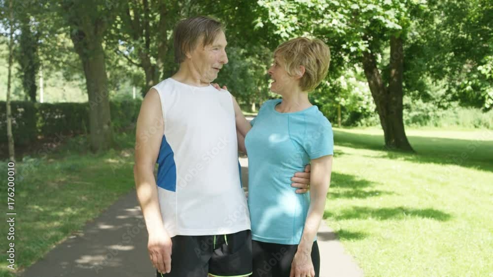 Portrait mature lady & senior man taking a break from exercising in the park Portrait mature lady & senior man taking a break from exercising in the park