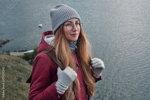 Mid age female portrait wearing glasses, traveling outdoor on gloomy day