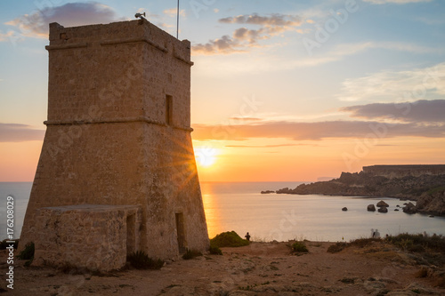 Beautiful golden sunset at Ghajn Tuffieha Tower, above Golden Bay, ancient watchtower built by the Knights of St. John, Golden Bay, Malta
