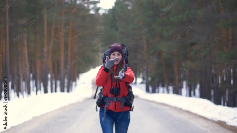 Happy tourist starting her trip, running along the road ina sunny winter forest. HD. Happy tourist starting her trip, running along the road ina sunny winter forest. HD.