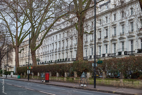 LONDON CITY - DECEMBER 24, 2016: Red mail box standing on Westbourne Terrace in front of a white residential building photo