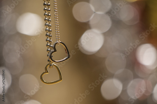 two hearts pendant necklace with glittering blurred background