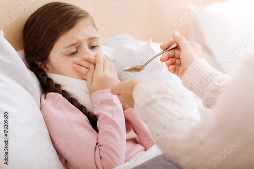 Bilde på lerret Emotional girl rejecting to drink a disgusting mixture