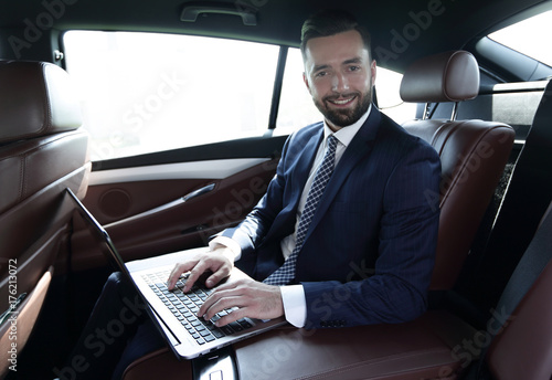 Businessman working on laptop keyboard sitting in car © ASDF