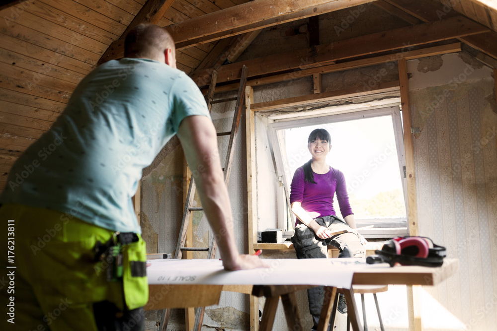 Couple making plans to renovate old attic Couple making plans to renovate old attic