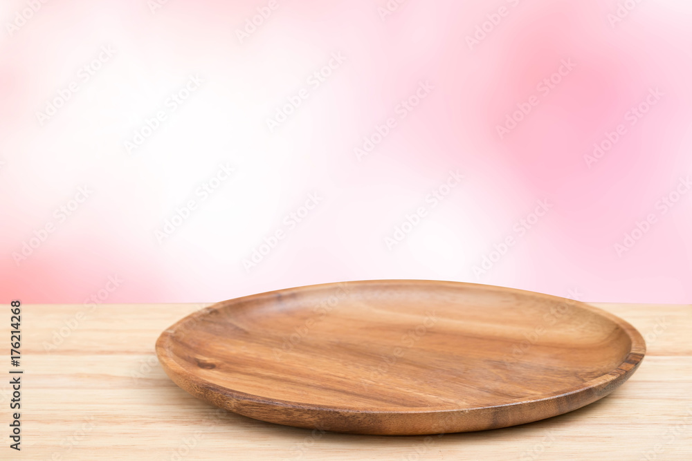 Empty wooden tray on perspective wooden table on top over blur natural background. Can be used mock up for montage products display or design layout.