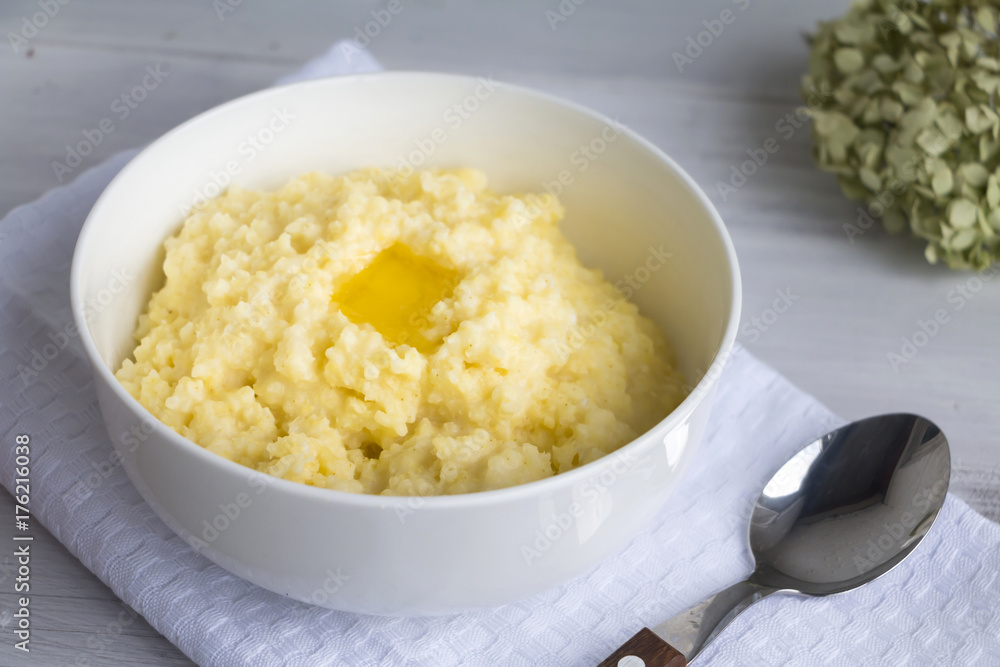 Millet porridge and melting butter in white bowl. Selective focus. Closeup. Millet porridge and melting butter in white bowl. Selective focus. Closeup.