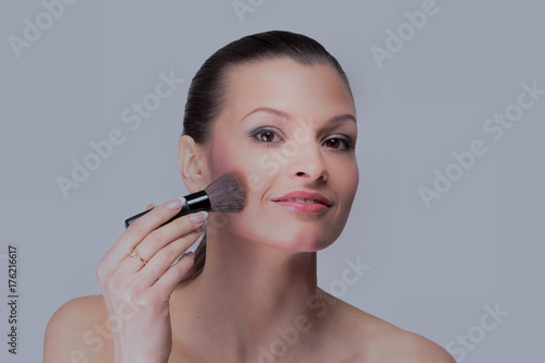 Smiling woman apply makeup