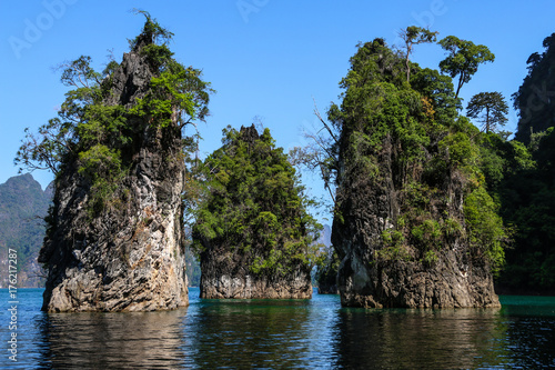 Beautiful landscape,natural attractions with mountains ,lake, tourist on raft boat,blue sky background in Ratchaprapha Dam at Khao Sok National Park,Suratthani ,THAILAND.  photo