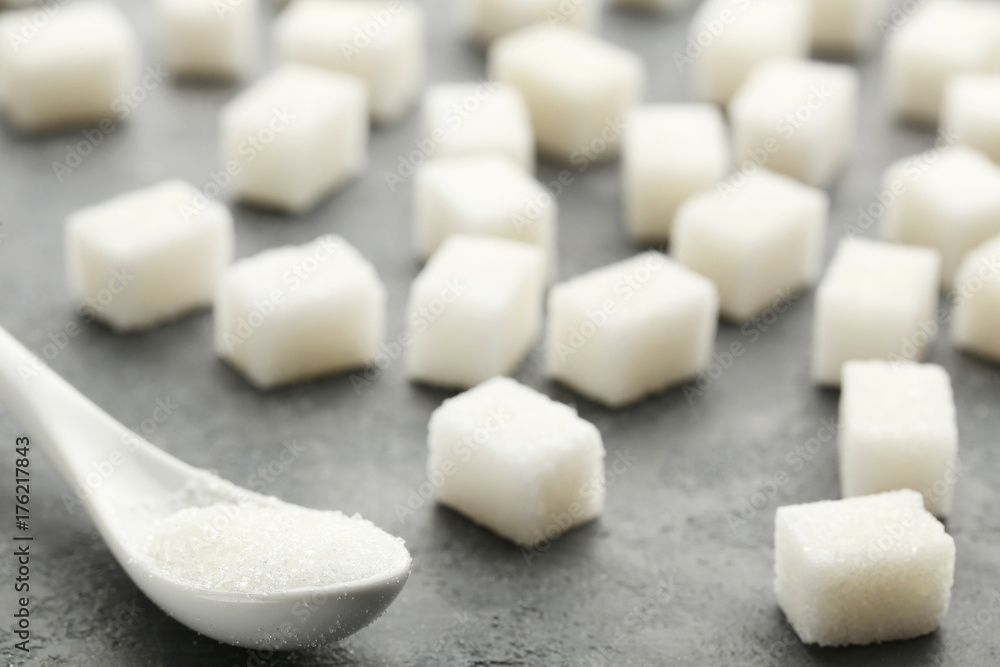 Sugar cubes with white spoon on grey wooden table Sugar cubes with white spoon on grey wooden table