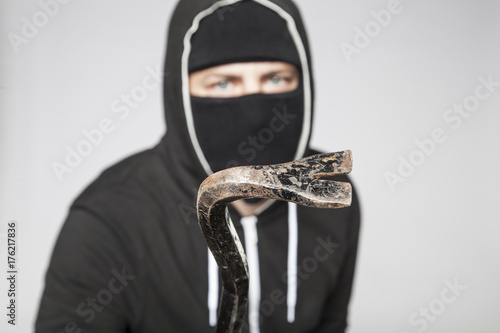 thief with a crowbar in his hand photo