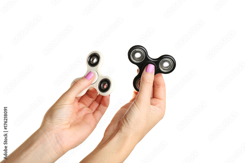 Female hands holding fidget spinner toys on white background Female hands holding fidget spinner toys on white background