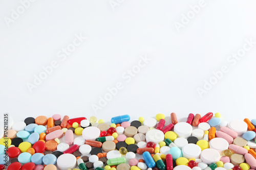 Different colorful pills on white background