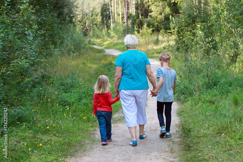 grandmother with grandkids-boy and girl- walk in nature