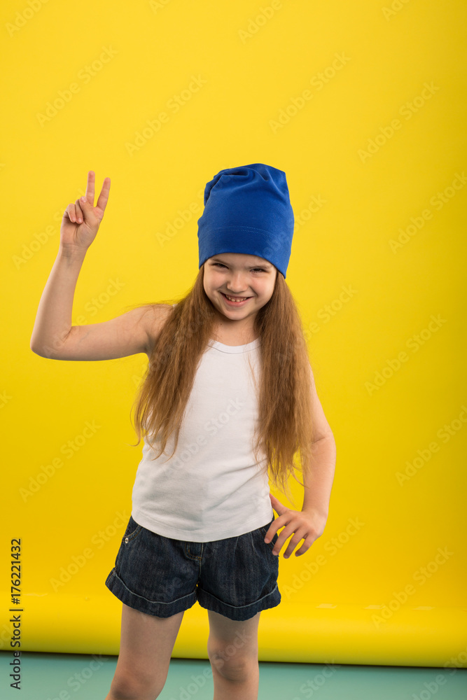 Beautiful caucasian girl posing in studio on a Yellow isolated background