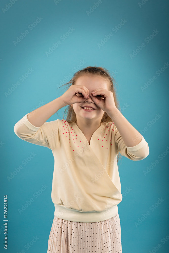 Portrait of a caucasian girl in the studio on a blue isolated background Portrait of a caucasian girl in the studio on a blue isolated background