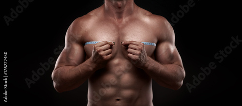 bodybuilder with a measuring tape around his chest © Aleksandr Doodko