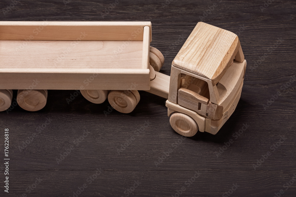 Truck, toy of wood, on dark background.