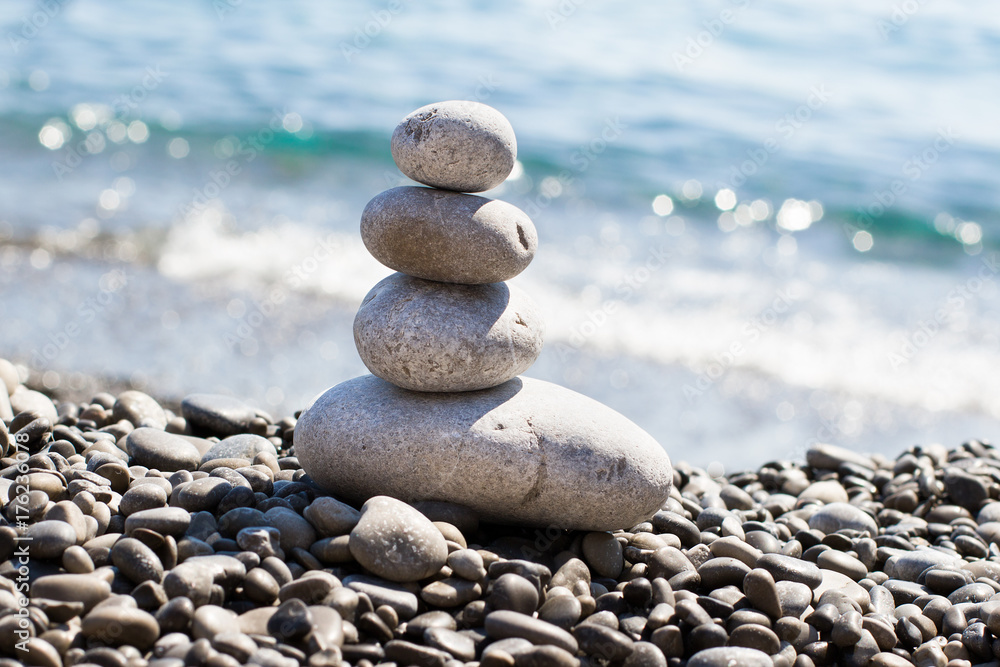 Zen sea stones (pebbles) stacked in a pyramid on sea coast. Inspiring stability concept. Concept of balance and harmony, relax, spa Zen sea stones (pebbles) stacked in a pyramid on sea coast. Inspiring stability concept. Concept of balance and harmony, relax, spa