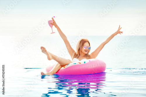 Summer Vacation. Woman in bikini on the inflatable donut mattress in the SPA swimming pool.