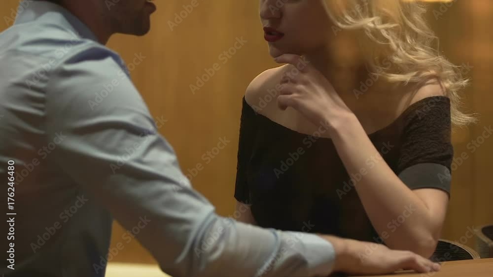Male and female sitting at bar table behind window, having argument, conflict Male and female sitting at bar table behind window, having argument, conflict