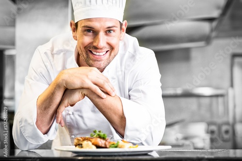 Smiling male chef with cooked food in kitchen photo