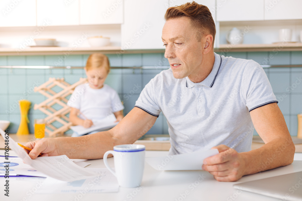Serious unhappy man reading a document Serious unhappy man reading a document
