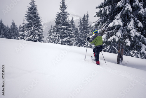 Traveler, in snowshoes, climbs up the slope