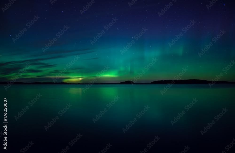 Northern lights dancing over calm lake. Farnebofjarden national park in Sweden. Northern lights dancing over calm lake. Farnebofjarden national park in Sweden.