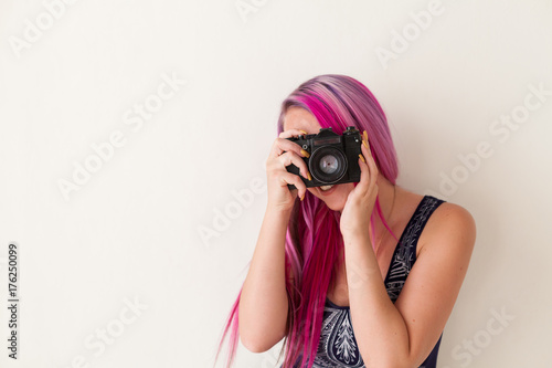girl with pink hair photographs camera