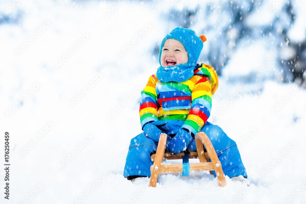 Boy on sleigh ride. Child sledding. Kid with sledge