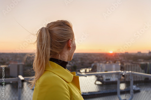 Canvas Print Woman admires the urban landscape at sunset