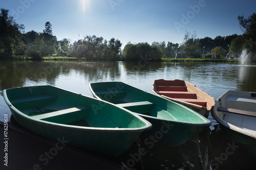 four rowboats laying in the water of a small lake