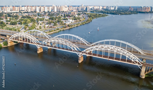 Aerial top view of automobile and railroad Darnitsky bridge across Dnieper river from above, Kiev (Kyiv) city skyline, Ukraine 