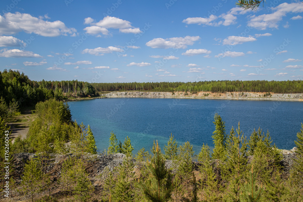 Abandoned flooded open pit quarry mine abestos ore with blue water