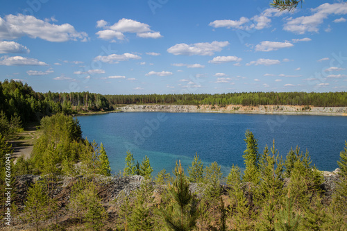 Abandoned flooded open pit quarry mine abestos ore with blue water