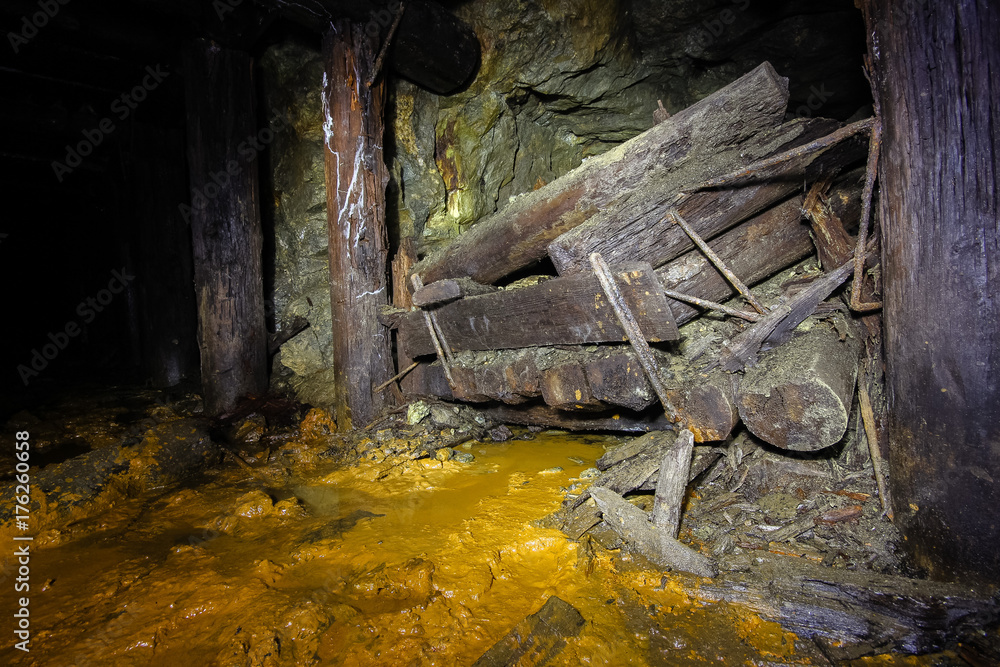 Undreground abandoned old mine shaft tunnel gallery passage with wooden timbering Undreground abandoned old mine shaft tunnel gallery passage with wooden timbering