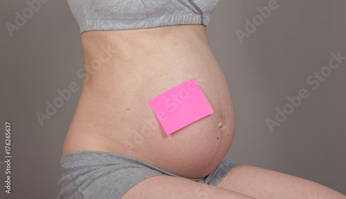 Wallpaper Mural sticker on pregnant belly on neutral grey background Torontodigital.ca