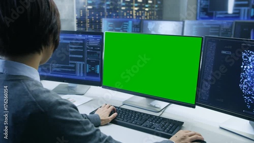 Wallpaper Mural Technical Controller/ Operator Working at His Workstation with Multiple Displays with Mock-up Green Screen. Possible Power Plant/ Airport Dispatcher/ Data Center/ Government Surveillance/ Space. Torontodigital.ca