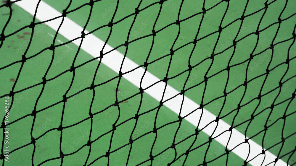 Fototapeta premium black tennis net on a green cement court