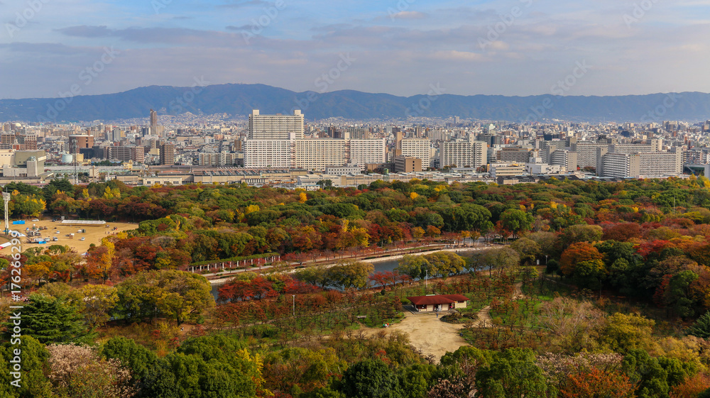 Osaka city with the park in autumn maple leaves in a fine clear blue sky day.