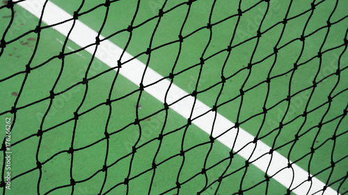 black tennis net on a green cement court