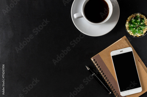 Flat lay of wooden office desk with smartphone notebook and plant. Top view with copy space. Business desk minimal style concept.
