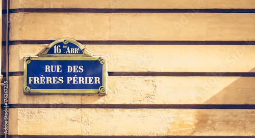 Photography blue parisian street sign on a stone wall