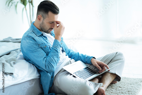 Tired businessman struggling with project at home