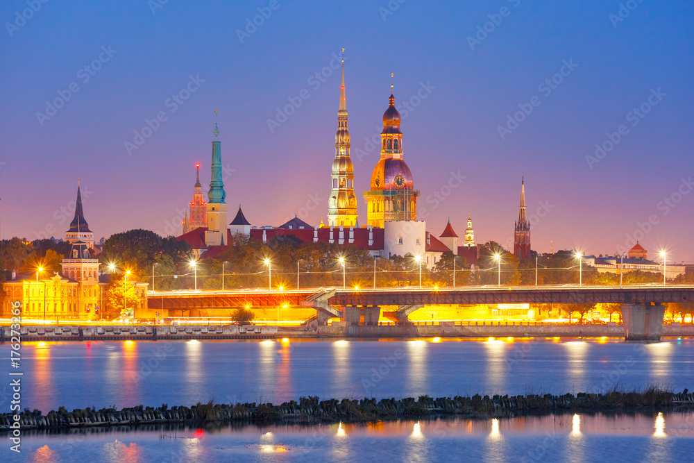 Obraz premium Old Town of Riga and River Daugava at night, Riga Cathedral, Saint Peter church and Riga castle in the background, Latvia