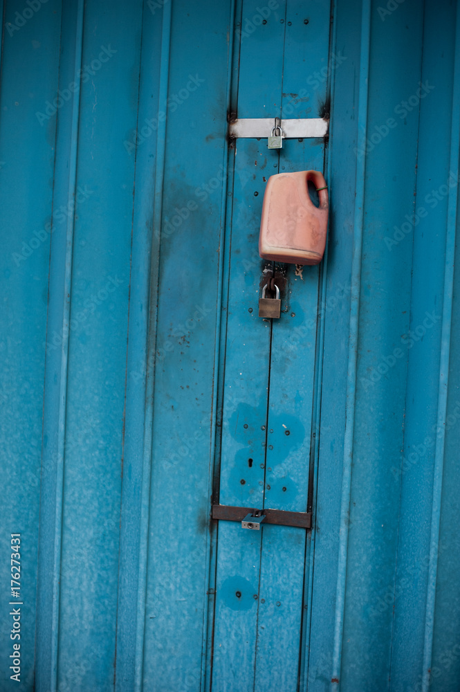rusty old school blue door with a padlock