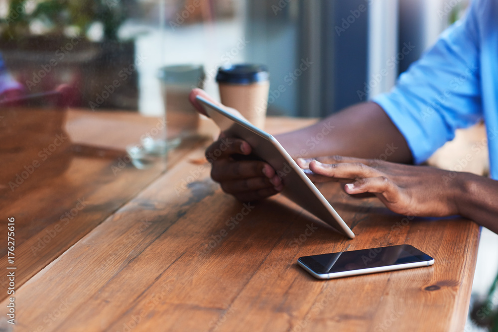Fototapeta premium Young man working online at a sidewalk cafe counter