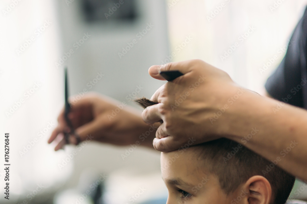 Little boy on a haircut in the barber sits on a chair. Little boy on a haircut in the barber sits on a chair.