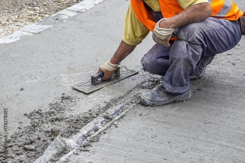 Worker leveling concrete with trowel